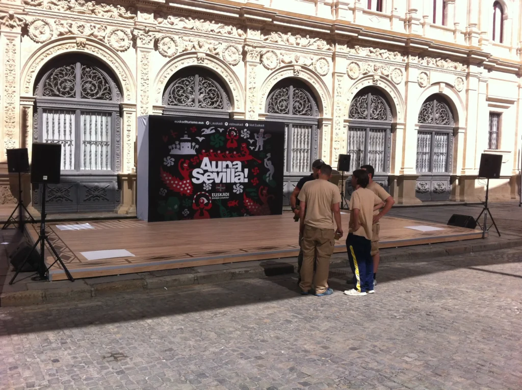 Technicians setting up a sound system on an outdoor stage in Malaga.