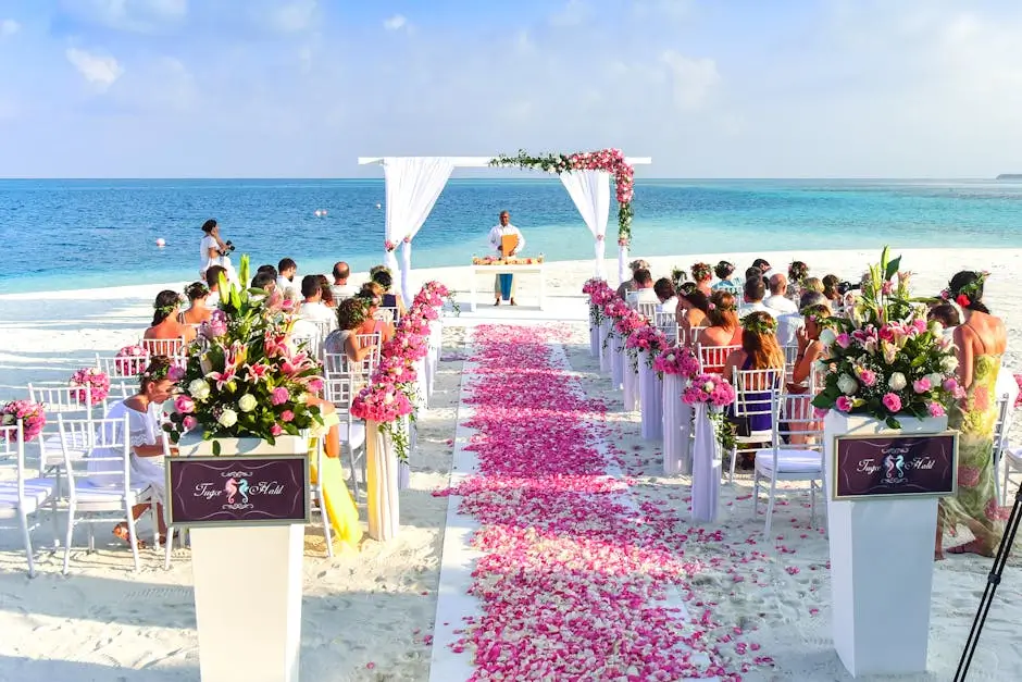 Tropical beach wedding arch with a petal lined aisle leading to the altar.