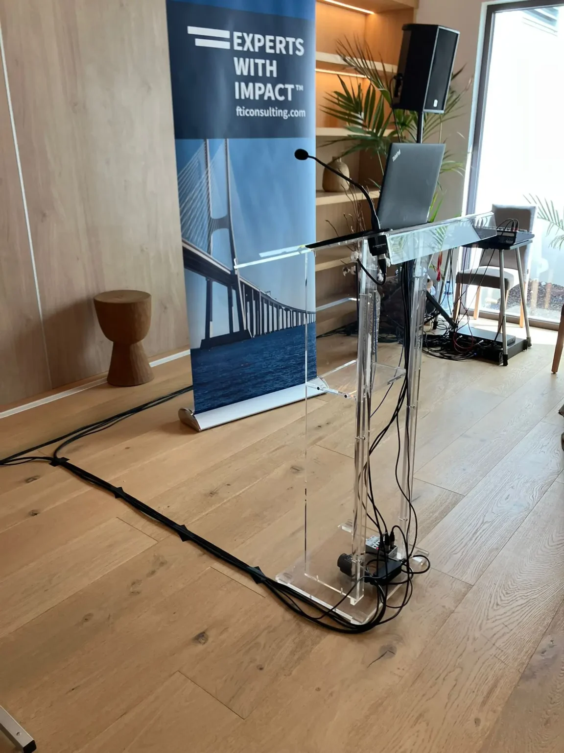 A professional FTI Consulting corporate presentation setup featuring a podium with a microphone and laptop.