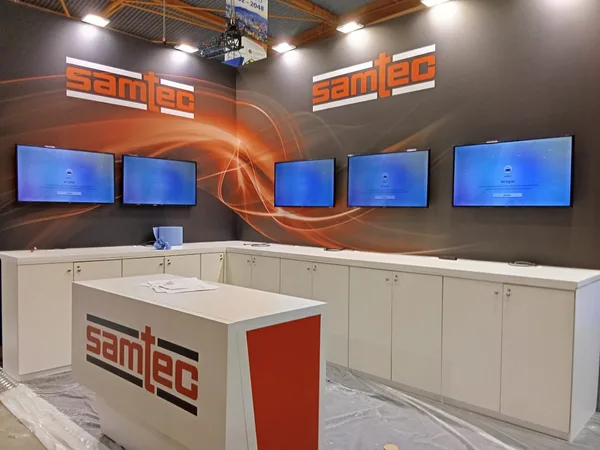 Five display screens installed in a row on an exhibitor stand at ECOC 2026, Malaga