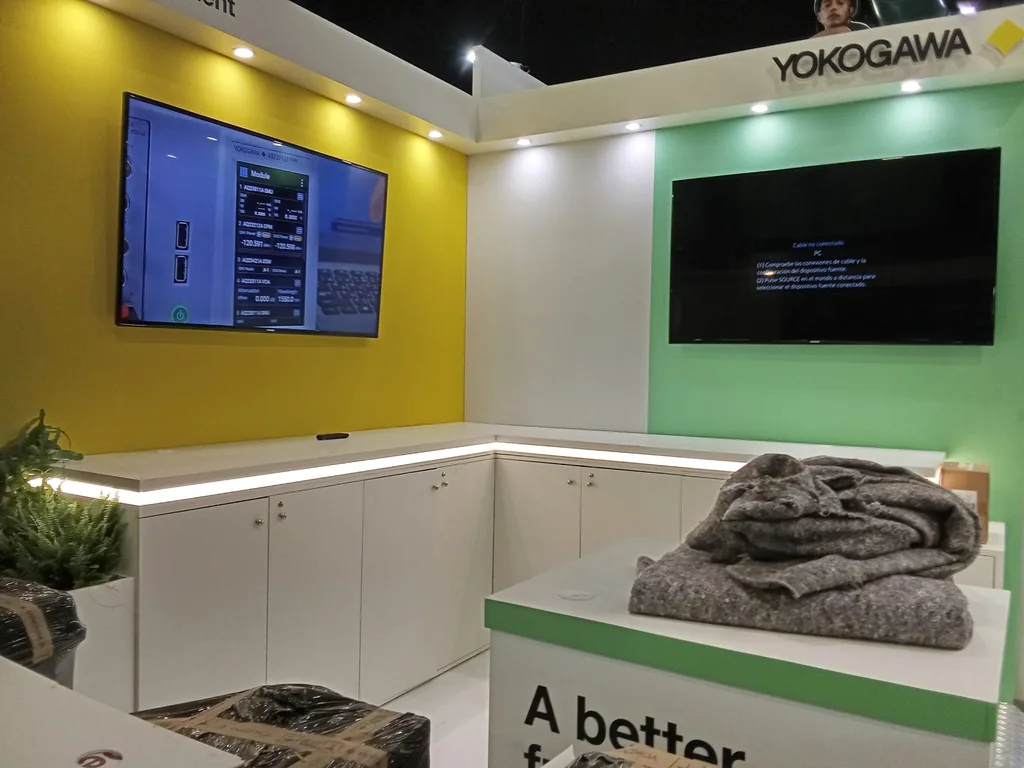 Two screens installed on adjacent stand walls at ECOC 2026, one already showing a live instrument interface and the other waiting for its source.