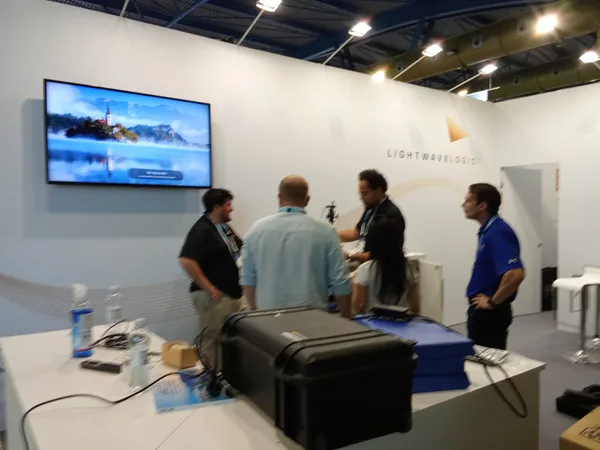 Visitors beside a stand display screen at the ECOC 2026 exhibition